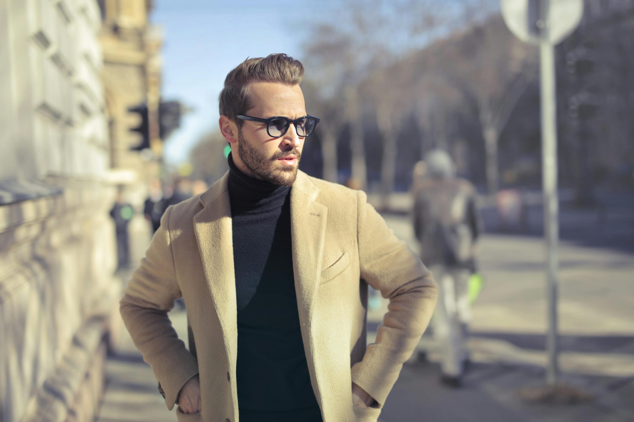 man wearing a camel coat over a black turtleneck